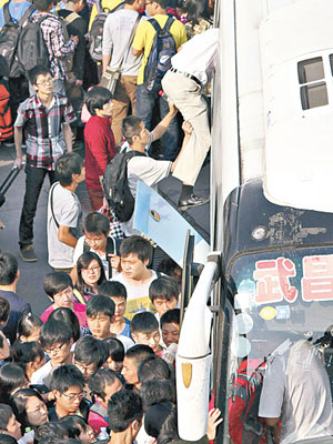 武漢<br>大批學生和回鄉人士在武漢宏基客運站排隊等候上車。（中新社圖片）