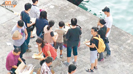 家屬在碼頭旁進行法事，祭祀死者。（鍾健國攝）