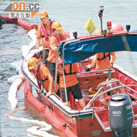 海事處人員更換吸油帶，防止「南丫IV」洩漏的燃油污染海水。