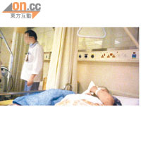 一名女病人在病床上休養，男病房助理人哥（左）則在旁「執床」。