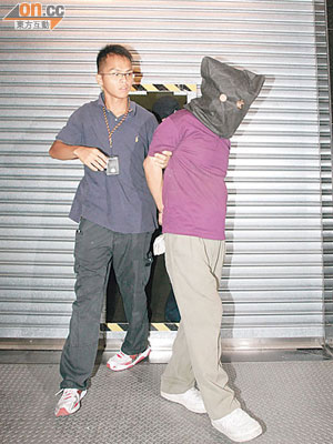 涉連環爆竊男子由警方押出大廈。（梁國雄攝）
