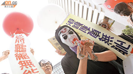 示威者戴上吸血鬼面具，把道具錢塞入口，諷刺港鐵吸小市民的血汗錢。（高嘉業攝）
