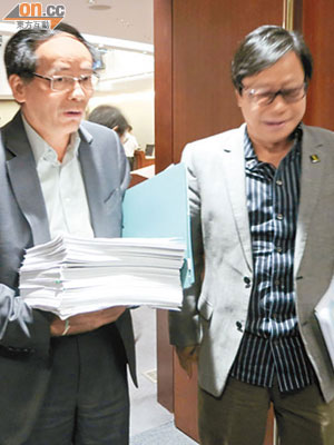 葉國謙（左）手持的五吋厚文件，就是黃毓民（右）等提出的千二項動議。（李惠攝）