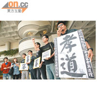 「青年撐退保聯合陣線」成員手持寫上「孝道」兩個大字的紙牌向梁振英請願。