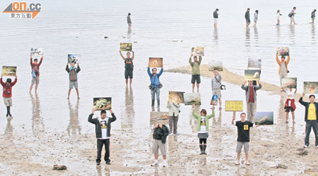 十多名守護龍尾大聯盟成員舉起龍尾海洋生物的圖片，希望政府不要遷移牠們，破壞海洋生態。（胡家豪攝）
