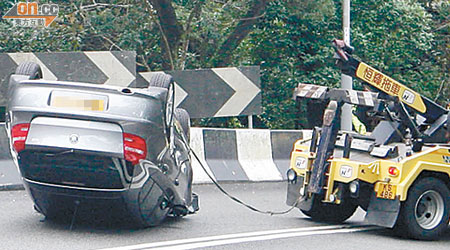 寶馬私家車撞壆，四輪朝天。（曾志恒攝）