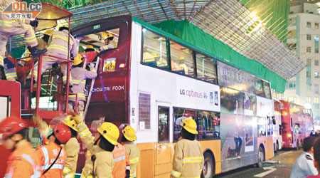 消防員打爛新巴上層車尾玻璃窗，爬鋼梯及架起升降台拯救被困乘客。（蔡楚華攝）