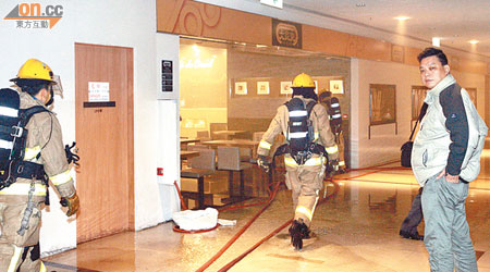消防員進入發生火警的快餐店灌救。（麥少峰攝）