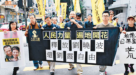 人民力量約卅名成員昨遊行至中聯辦，促中央釋放劉曉波及停止軟禁其妻劉霞。