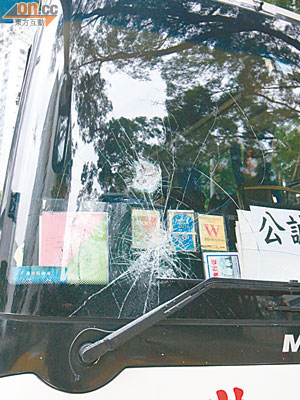 旅遊巴士的擋風玻璃被黑衣漢用鐵錘擊毀。（梁卓明攝）