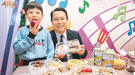 黃瀚琛（左）在校吃的飯盒「多菜少肉」，助曾患血癌的他更加健康。旁為黃父。