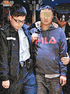 警員將涉嫌襲擊控煙辦職員的男子押走。（李國健攝）