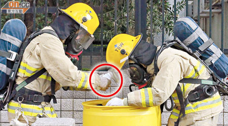 佩戴保護裝備的消防員，用膠樽（圓圈示）盛載化學品作進一步檢驗。（林明強攝）