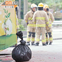 消防員將化學品放入黑色大膠袋，以策安全。