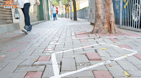 東大街行人路疑因樹木根部生長致凹凸不平，有街坊自發貼上膠紙警示途人。