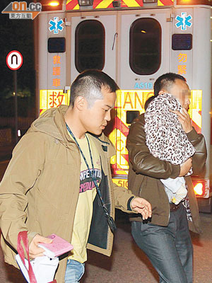 被捕內地丈夫（右）抱同初生兒子到醫院接受治療。