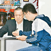 藥行東主兼中醫師陳賀濤（左）昨如常應診。（戴展邦攝）