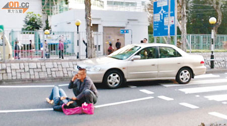 過路女子被私家車撞傷倒地，同行胞弟在旁照顧。（讀者提供）