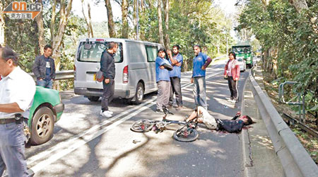 踩單車男子疑被泥頭車勾倒，頭部重傷倒臥地上。（文健雄攝）