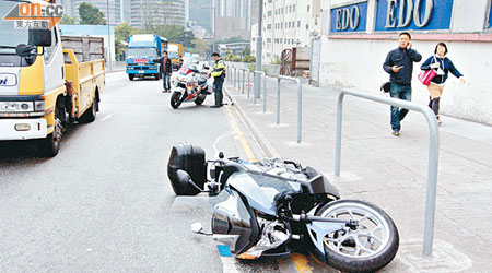 肇事電單車衝前後翻側路旁。（梁卓明攝）