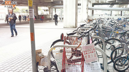 西鐵屯門站F2出口單車停泊處常堆積垃圾及廣告牌，卻分別由不同部門負責處理。