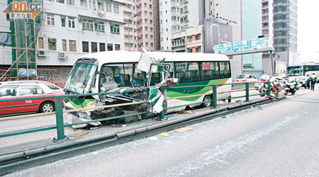 校巴狂撼鐵欄遭削開左邊車身。（許錦雄攝）