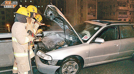 消防員向着火私家車射水灌救。（吳建明攝）