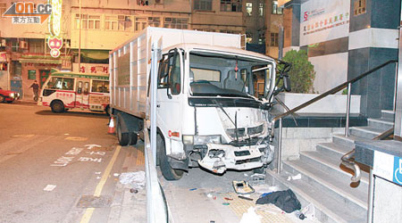 失事垃圾車剷上龍鳳街行人路，撞毀路標及鐵欄。 （馮戈攝）