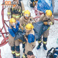 前年十一月發生的花園街大火，消防員從災場抬出屍體。