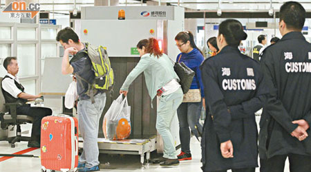 海關人員會要求行李較多的旅客，將行李放入Ｘ光機檢查。（霍振鋒攝）