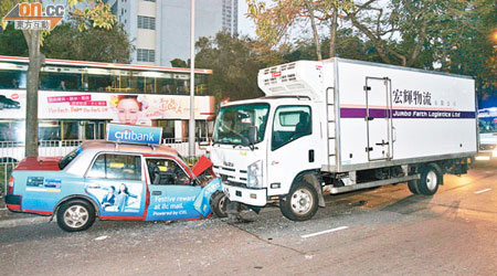 肇事的士與凍櫃車相撞，車頭均損毀。（楊日權攝）