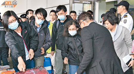 埃及熱氣球慘劇死難者何氏三兄妹的四名家屬返港後，由入境處職員陪同下離開機場。（蘇文俊攝）