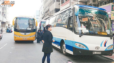 旅遊巴在行人路中心停泊，並讓旅客登車，造成阻塞。