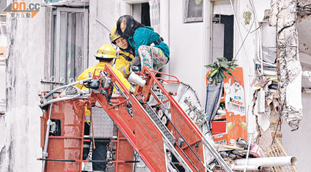 事發唐樓倒塌後，消防員到場用雲梯拯救被困毗鄰大廈的住客。