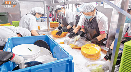 中央洗碗工場聘有工人，負責將餐具「過水」、放進洗碗碟機等工作。（羅錦鴻攝）