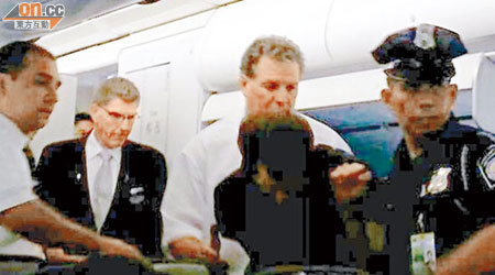 警員將涉打人外籍男子帶離飛機。（讀者提供）
