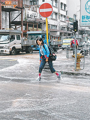 有市民索性用膠袋包裹充當「水靴」涉水而行。（梁國雄攝）