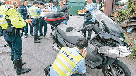 警員檢查涉意外的被盜電單車。（林明強攝）
