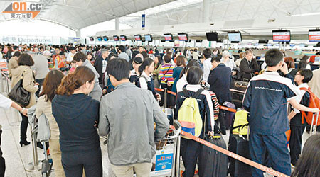 機場多個辦理登機手續的櫃台出現長人龍。（蕭毅攝）