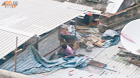 工人在屋頂施工，將寮屋「增高」。（讀者提供）