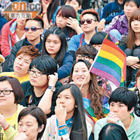 部分人高舉代表同志平權的彩虹旗支持活動。