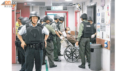 葉繼歡坐在輪椅推離醫院，警員及懲教署人員嚴陣押送。（陳桂建攝）