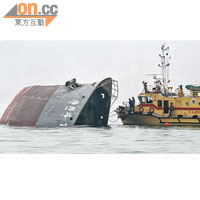 沉沒的內河船「海邦達199」號僅露出船頭，消防娃人落海搜救。