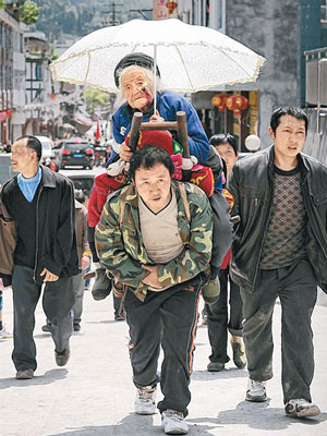地震重災區蘆山縣太平鎮一名男子背着受傷老婦趕往臨時救治點。（中新社圖片）