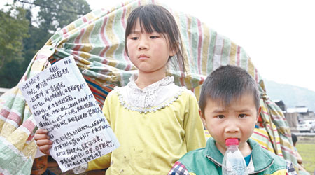 重災區蘆山龍門鄉一位九歲女童抱着弟弟逃難後，在抗震棚外寫地震日記。（中新社圖片）