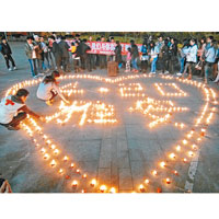 福建福州市民在廣場燃點蠟燭為雅安災民祈福。（中新社圖片）