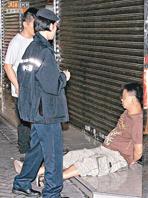 新蒲崗<br>被捕疑犯雙手扣上手銬，坐於地上由警員看守。
