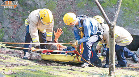 消防員游繩落山坡救起重傷事主。(林振華攝)
