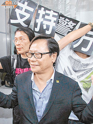 黃毓民到場時高舉勝利手勢，建制派支持者則在後方高舉「支持警方」的標語。（陳錦輝攝）