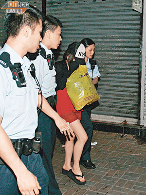 在街頭被掌摑的女子，手持膠袋由警員帶署調查。（楊偉嶽攝）